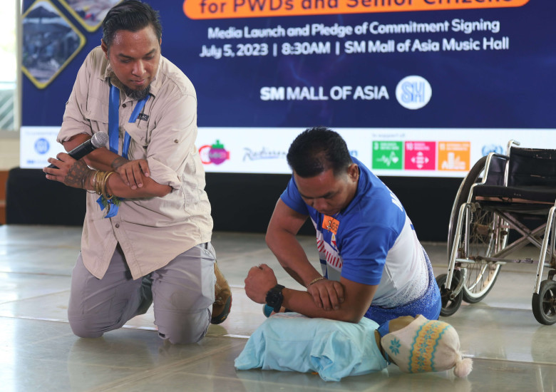 Disaster Management Specialist Doki Natividad teaching a PWD delegate the cardiopulmonary resuscitation (CPR)
